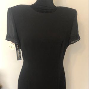A line black dress , with appliqué on sleeves , zippered back .lined .